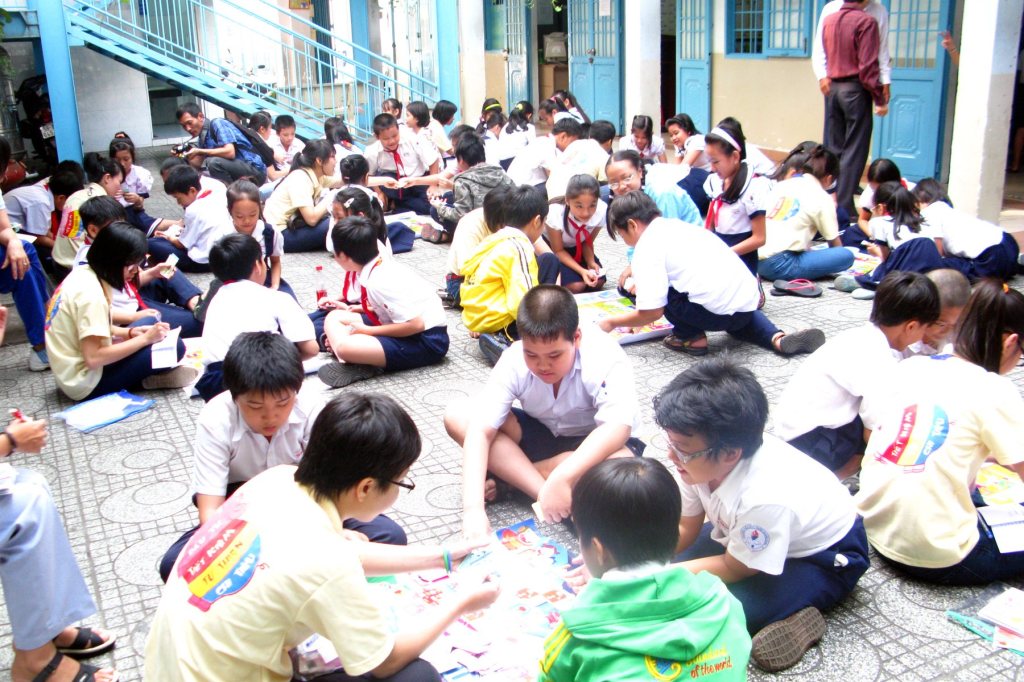 Hàng trăm học sinh trường Trần Quang Khải ngồi theo nhóm chơi board game Làm Chủ Đồng Tiền giữa sân trường