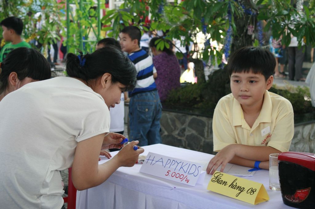 Bạn nhỏ trông gian hàng của nhóm