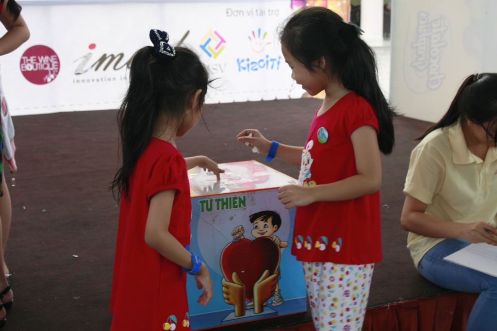 Bạn nhỏ bỏ tiền vào hộp từ thiện