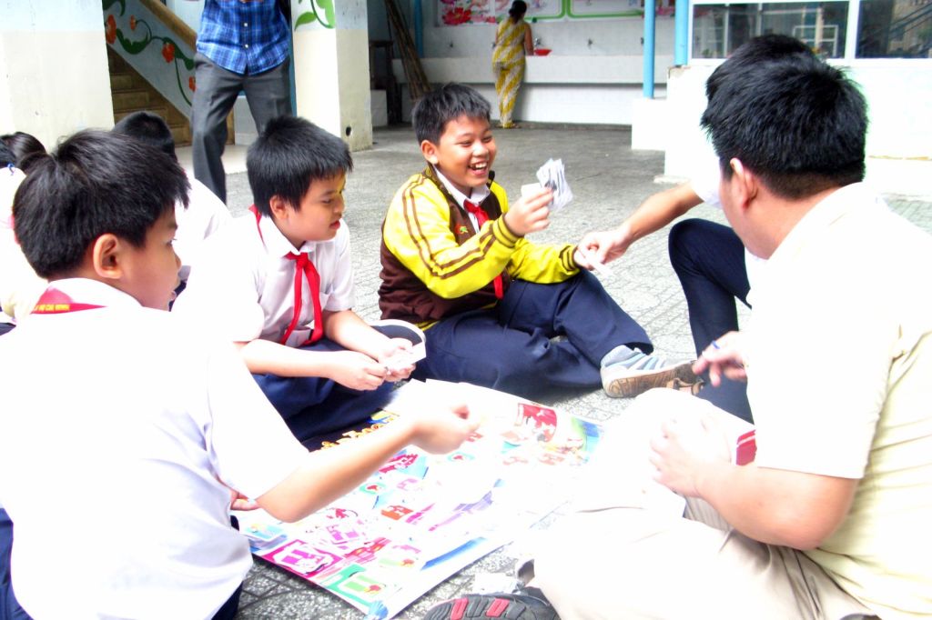 Nhóm học sinh chơi board game cùng huấn luyện viên