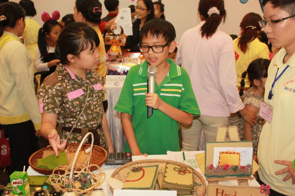 Bạn nhỏ cầm micro giới thiệu gian hàng